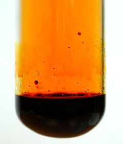 Red-brown liquid bromine with brown bromine vapour above