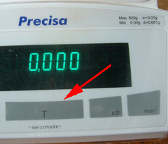 The tare button on a top pan balance